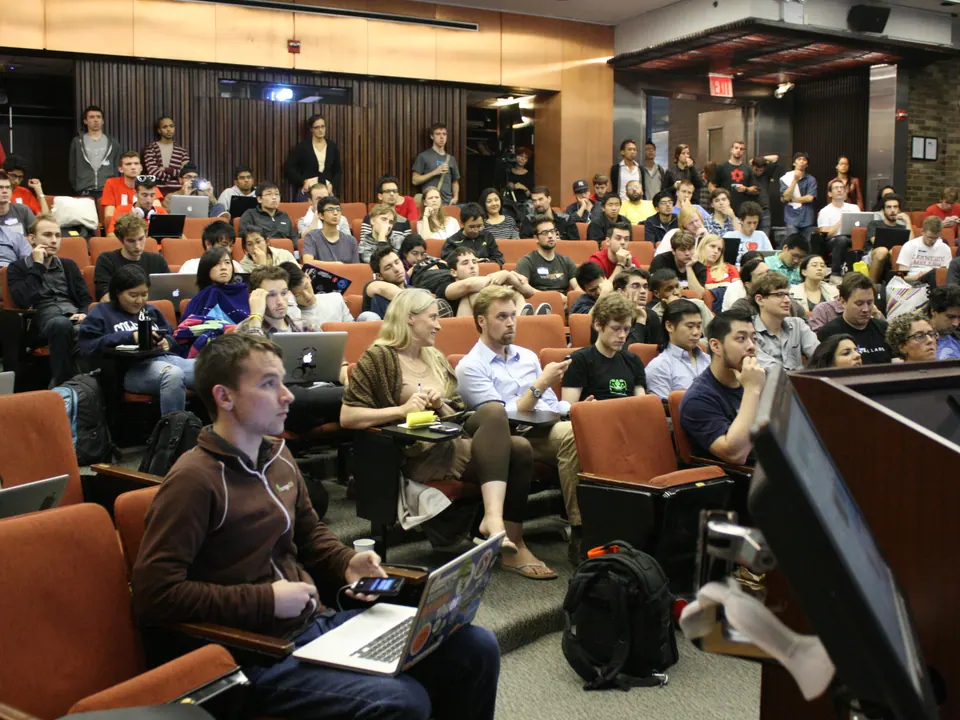 A lecture hall full of people with laptops open, working